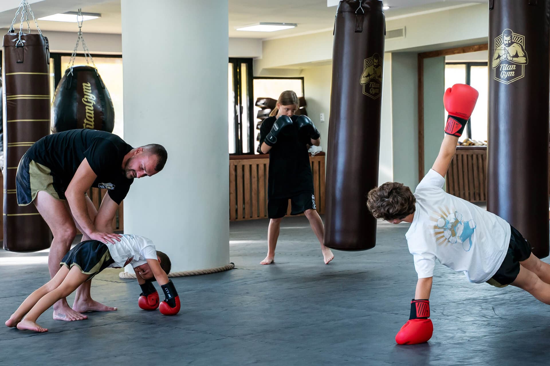 Deti na letnom bojovom tábore v Titan Gym Bratislava — tréning s trénerom